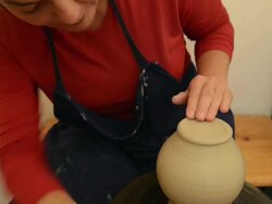 MS TU Shot of female potter finishing and smoothing out pitcher on potterwheel at pottery / Landshut, Bavaria, Germany Stock Footage