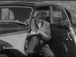 1953: WESTCHESTER SPORTS CAR CLUB: ROAD RALLY: VS Members listening to instructions, reading directions, checker clearing MG to go. LA WS (POV Back of moving vehicle) Bentley driving from airport meeting place, dust flying from lead camera car. Instructional Video