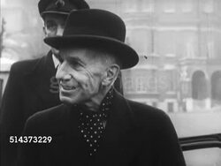 1952: CANADA: GOVERNMENT: Governor General Vincent Massey (1887-1967) standing outside car talking w/ unidentified man (No SOT), driver standing BG. Angled WS 1952 Chrysler car w/ suicide doors pulling away from curb. Instructional Video