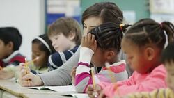 Teacher works with her elementary school students in class Stock Footage