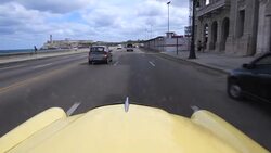 An old convertible American car working as tourist taxi and driving the 'Malecon' Stock Footage