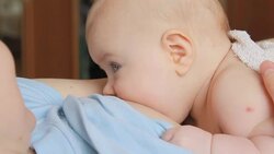 Mother breastfeeding her baby lying on back Stock Footage