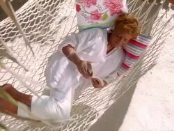 MS ZO Dark skin senior woman reading book while relaxing in swinging hammock on beautiful sunny day / Cleatwater, FLORIDA, USA Stock Footage
