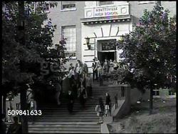 1945: HYATTSVILLE HIGH SCHOOL: WS Students exiting high school entrance steps. INT WS Students in biology class, teacher at table w/ microscope FG. Instructional Video