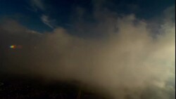 Clouds drift above a city far below. Stock Footage