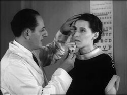 B/W 1936 doctor giving woman eye exam to fit her for contact lenses / newsreel Stock Footage