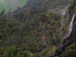 Wing suit flier descends from cliff, aiming for valley below Stock Footage