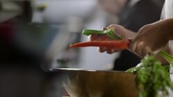 Restaurant cooks peel carrots in busy kitchen restaurant Stock Footage