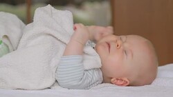 baby lying alone and sneezing Stock Footage