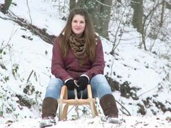 MS girl sitting on sled in winter and after walking out from forest / Saarburg, Rhineland-Palatinate, Germany Stock Footage