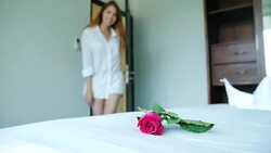 Woman come in the room and surprising rose in bed Stock Footage