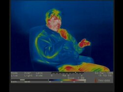 Thermographic imaging, MCU man sitting in armchair smokes cigarette Stock Footage