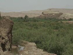Trees and shrubs spring up from the stark landscape, whilst vast hills surround the landscape.  Stock Footage