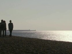 MS, Family with two children (10-11, 12-13) walking on Brighton beach at sunset, Brighton, Sussex, United Kingdom Stock Footage