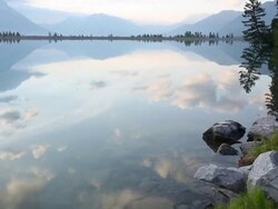 Young man walks to shoreline of mountain lake Stock Footage