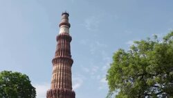 A view of the Qutb Minar towering over the Qutb complex, scattered with ruins and tombs. Stock Footage