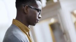 Young shop employee tags shirts in clothing store with tagging gun Stock Footage