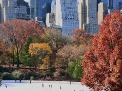 WS TU Shot of Ice skate rink and autumn color trees and Manhattan skyline / New York, United States Stock Footage