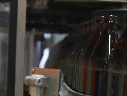 CU R/ F Brown glass beer bottles on conveyor / Wau, Western Bahr el Ghazal, Sudan  Stock Footage