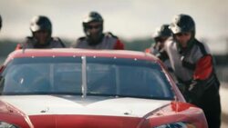 Pit-crew team pushes race-car Stock Footage