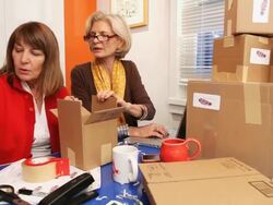MS TD TU Women taping boxes and using laptop / Los Angeles, California, USA Stock Footage