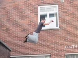 A young man doing a parkour freerunning jumping and flipping stunt. - Slow Motion - Model Released - 1920x1080 - HD Stock Footage