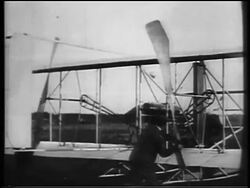 B/W 1900s Wright brothers starting propeller on biplane / documentary Stock Footage