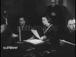 1940: VATICAN CITY: CANONIZATION: Female witness reading evidence of Miracle (no SOT) to Cardinals at table, signing paper.   Canonization, Saint. Instructional Video