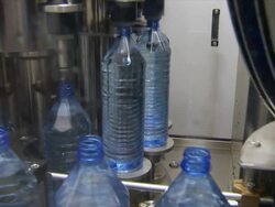MS Machine rotating full plastic water bottles and placing them on conveyor / Wau, Western Bahr el Ghazal, Sudan  Stock Footage