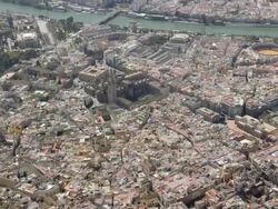 circling aerial view of the historic center of Seville with cathedral and La Giralda in center, bullring 'La Meastranza' to the right, Guadalquivir river in background Stock Footage