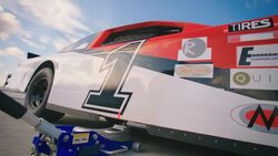 Pit-crewman jacks race-car Stock Footage