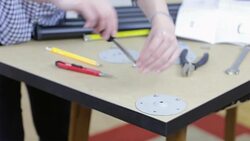 Young woman carpenter reading instruction to assemble furniture and screwing into wood. Stock Footage