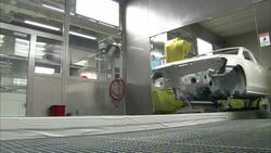 A conveyor moves an auto body along tracks in an automotive plant. Stock Footage