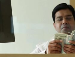 Bank Teller counting money at bank counter, Delhi, India Stock Footage