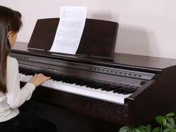 Young girl plays piano Stock Footage