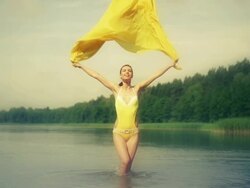 Woman jumping in water holding yellow scarf Stock Footage