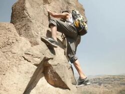 Young man climbing a cliff of mountain  Stock Footage