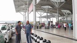 passengers boarding radio taxis and the scheduled information display of departure and arrival at the exit of an airport terminal Stock Footage