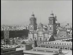 1946: MEXICO CITY: CU 'Mexico' illustrated poster. WS Mexico City. WS La Plaza de la Constitucion (AKA El Zocalo) building. WS Cattle on street, trucks FG. VS Cars, buildings, Mexicans riding burros (or donkey) on street. VS Presidential Palace. Instructional Video