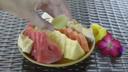 Woman pouring lemon juice over fresh Fruit salad Stock Footage