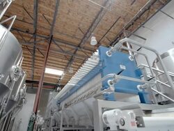 WS PAN from micro brewery mash filter array of high efficiency brewing system to stainless steel fermenting vessels / Thousand Palms, California, USA Stock Footage