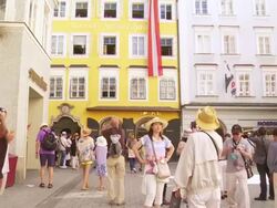 TILT UP Tourists Regarding the Birthplace of Wolfgang Amadeus Mozart in Salzburg Stock Footage