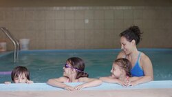 Young ethnic swimming instructor working with children in pool Stock Footage