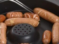 Frankfurter sausage being backed in pan Stock Footage