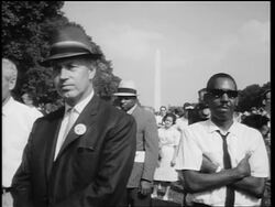 B/W August 28, 1963 Black + White men listening to King's speech at March on Washington Stock Footage