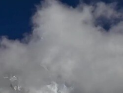 Panning shot of Time-lapse of clouds passing in front of a Himalayan peak. Stock Footage