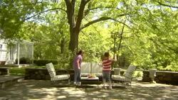 WS, USA, New York State, Bedford Hills, two girls (6-9 years) running up and seating at outdoor seating area in back garden Stock Footage