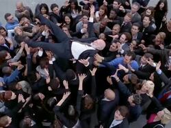High angle wide shot older man being held up by crowd of businesspeople Stock Footage