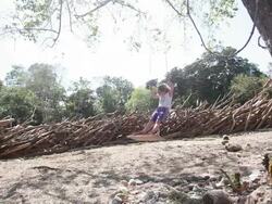 MS Little girl standing on swings pushes herself in natural playground / Montezuma, Nicoya Peninsula, Costa Rica  Stock Footage