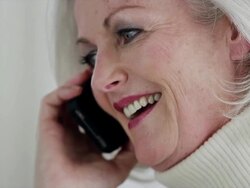 CU tilt up senior woman on mobile phone laughing and smiling Stock Footage